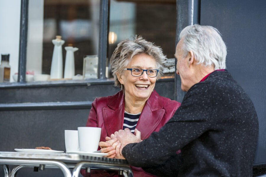 Ouder stel hand in hand op terras -  ervaringsverhaal beschermingsbewind toekomstplanning